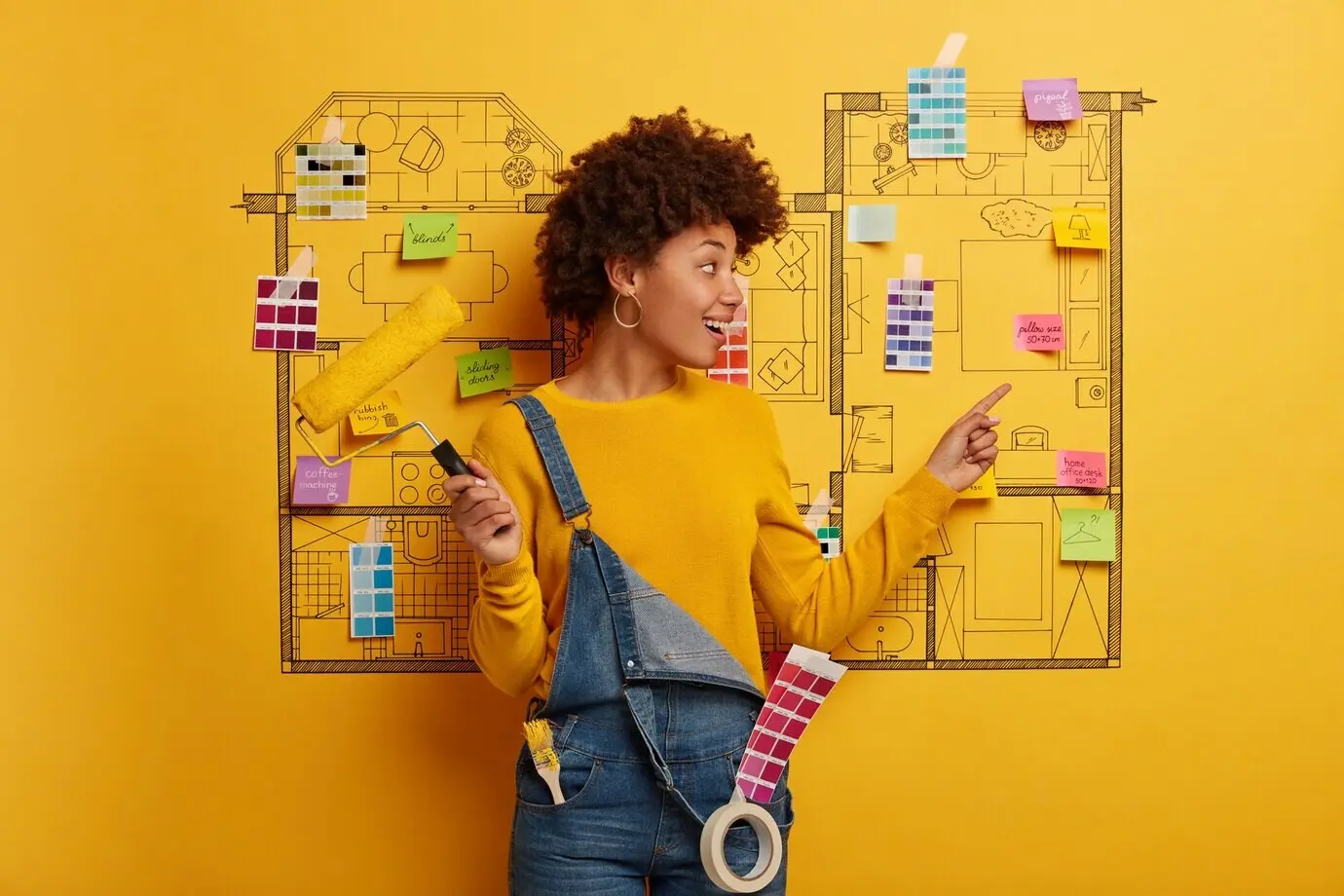 Junge Frau steht neben einer Hausentwurfs-Skizze, bereit zur Renovierung.