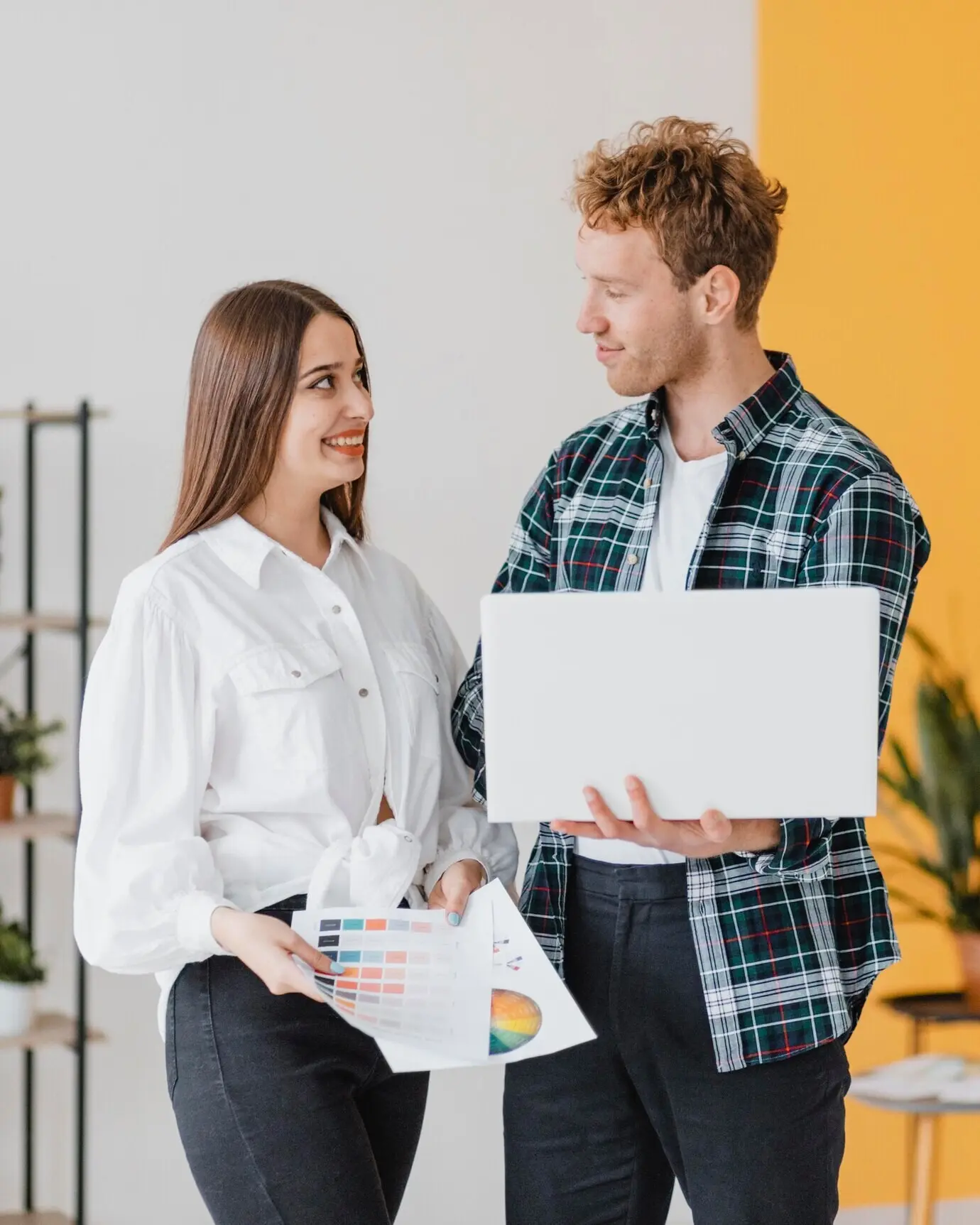 Frontalansicht eines lächelnden Paares, das gemeinsam plant, das Zuhause neu zu dekorieren.